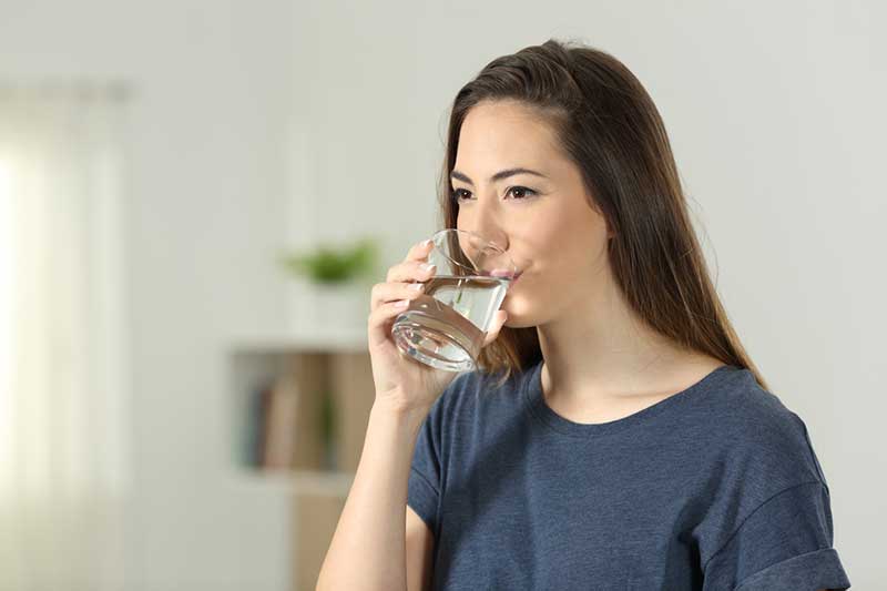 woman drinking glass of clean water